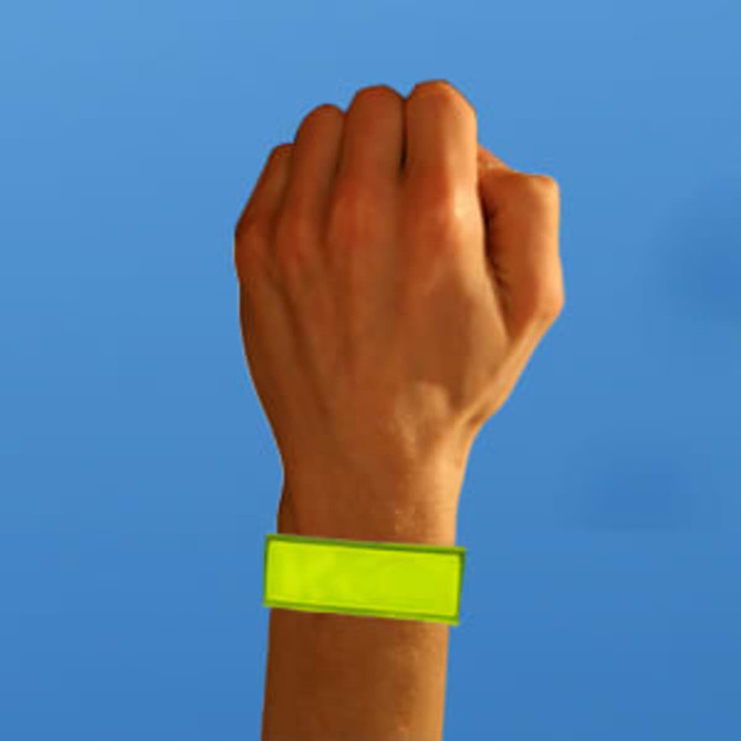 A hand wearing a bright yellow reflective wristband against a blue background. The wristband features a blank rectangular area.