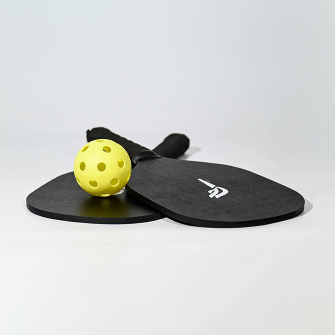 A black pickleball set featuring two paddles and a yellow ball, with a logo on the paddles.