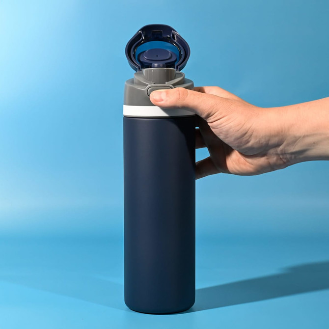 A drink bottle in navy blue with a grey top, featuring a flip cap and a holding hand.