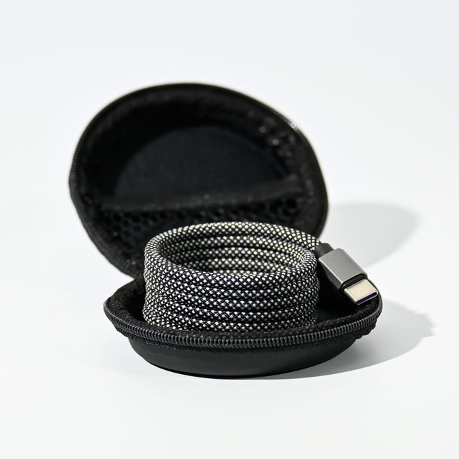 A charging cable in a round black case, featuring a sleek, woven design in grey tones.