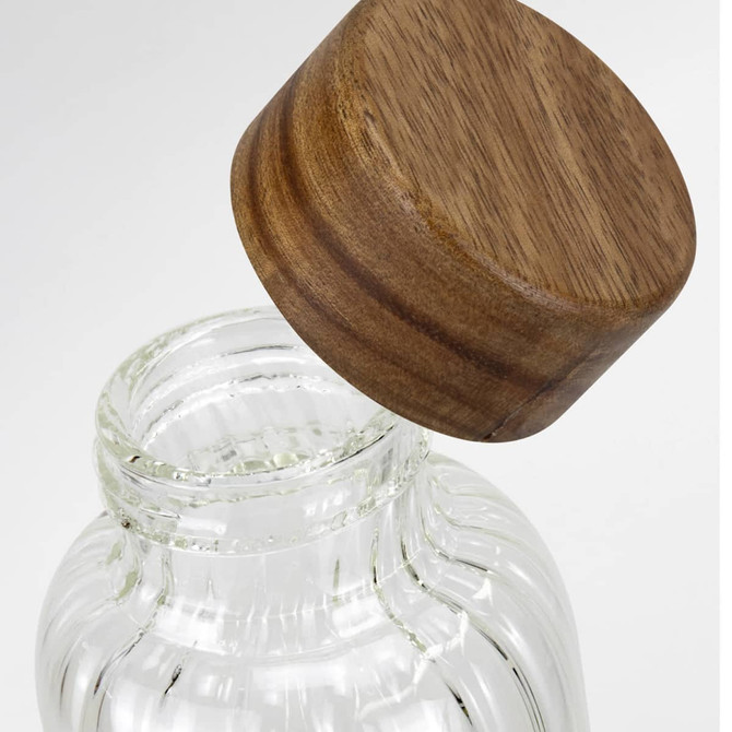 A drink bottle with a clear glass body and a wooden lid, featuring a simple, elegant design.