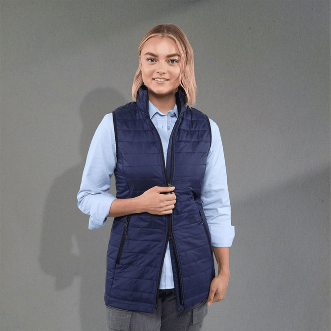 A navy insulated puffer vest with a zip front and side pockets, worn over a light blue shirt.