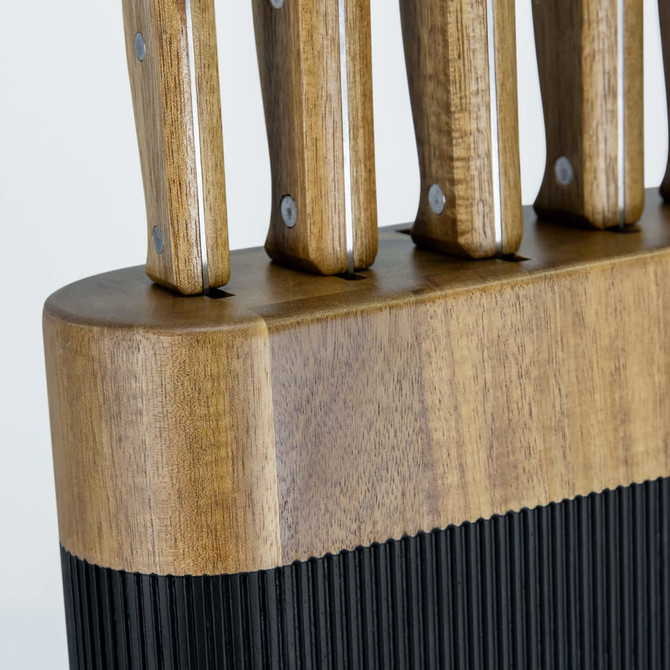 A wooden knife block in natural tones, featuring slots for knives with metallic accents and a textured black base.