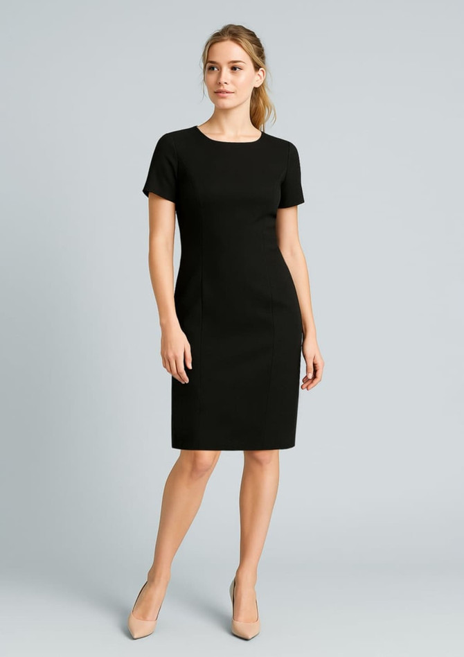A fitted black short sleeve shift dress with a crew neckline, paired with neutral-coloured heels.