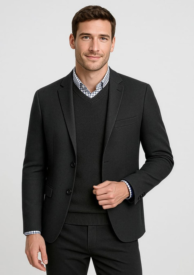 A tailored black blazer over a black sweater, paired with a checkered shirt underneath. The model is smiling.