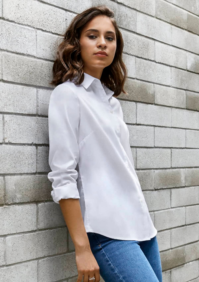 A white long sleeve button-up shirt with a sleek design, displayed against a grey brick wall.
