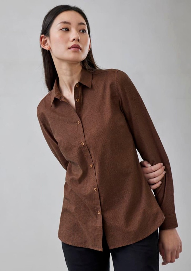 A brown long sleeve button-up shirt featuring a collar and a relaxed fit. The model displays a side profile.