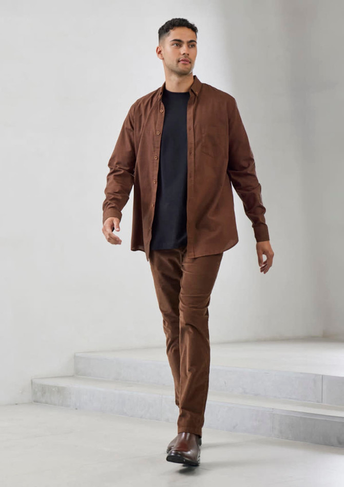 A brown long sleeve button-up shirt worn over a black top, paired with matching brown trousers and shoes.