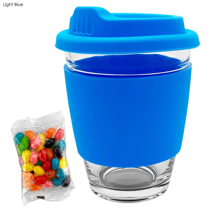 A light blue Carlo glass coffee cup with a silicone lid and sleeve, paired with a bag of colourful jelly beans.