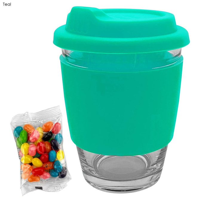A teal coffee cup with a silicone sleeve and a clear glass base, accompanied by a pack of colourful jelly beans.