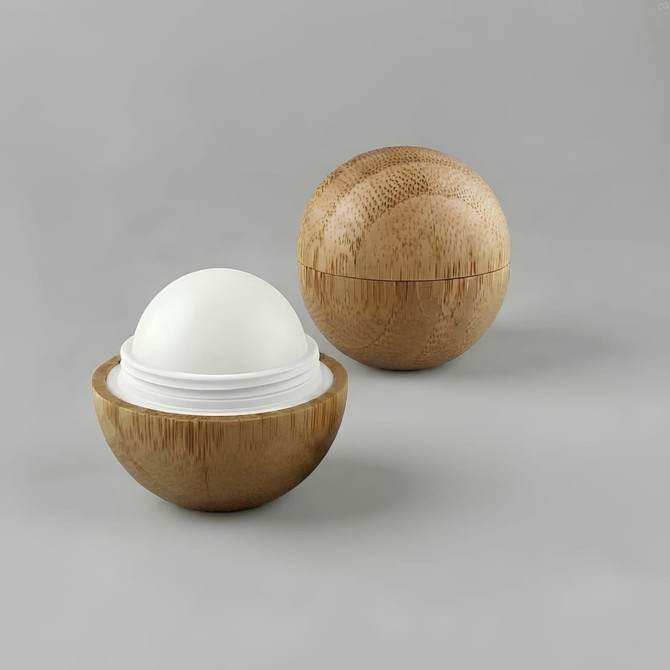 A bamboo lip balm ball featuring a smooth, white balm inside a round, natural bamboo shell.