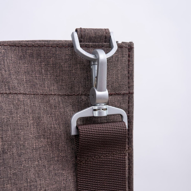 A close-up of a grey nylon bag featuring a metal clip and a brown strap. The bag has a simple design with a logo.