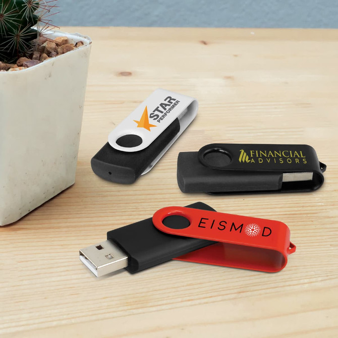 Three Helix 8GB flash drives in black, red, and white, sitting beside a small potted plant on a wooden surface.