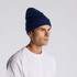 A navy blue cuff beanie displayed on a model, featuring a ribbed texture and a snug fit.