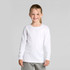 A long-sleeve white t-shirt for kids, featuring a crew neckline. The model is smiling and wearing grey bottoms.