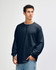 A black unisex long sleeve t-shirt displayed on a model, featuring a relaxed fit and a logo on the chest.