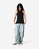 A black racerneck tank top with a fitted design, worn with light blue cargo pants and styled with black and white sneakers.