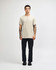 A beige unisex Henley T-shirt featured on a model paired with light blue jeans and black sneakers. The shirt has a logo.