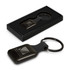 A square black key ring with a smooth finish, presented in a sleek black box, featuring a logo.