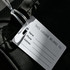A black imprinted mini luggage tag featuring a blank white information card for name, phone, and address.