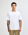 A white American Apparel Super Heavyweight T-Shirt displayed on a model. The shirt has a relaxed fit and short sleeves.