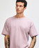 A model wears a purple American Apparel Super Heavyweight T-Shirt, featuring a simple design and relaxed fit.