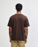A brown t-shirt with short sleeves, viewed from the back, featuring a logo.