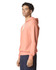 A lightweight hooded sweatshirt in coral with a drawstring hood, showcased on a model from the side.