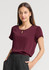 A maroon women's short sleeve blouse with a keyhole detail at the neckline, paired with black trousers.