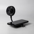 A black rechargeable fan with a flexible neck, positioned next to a mobile phone on a flat surface. It features a branding logo.