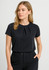 A black short sleeve women's top features pleats at the neckline, paired with tailored trousers. The image includes a logo.