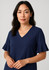 Navy blue blouse featuring fluted sleeves and a V-neckline, modelled by a woman with dark hair.