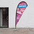 A small tear drop flag kit featuring a pink and blue design, supported by a metal base. Includes a branding logo.