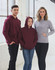 A maroon hoodie worn by a man and a girl, and a grey hoodie worn by a woman, displayed in a light-filled setting.