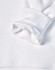 A close-up of a white fleecy hoodie sleeve featuring a soft, textured cuff. It has a logo on the fabric.