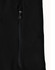 A close-up of a black softshell jacket featuring a zipped pocket and a branded logo.