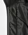 A black quilted jacket featuring a heather sleeve and a zippered pocket on the interior.