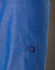 A close-up of a blue women's shirt featuring a button and a rolled-up sleeve. The fabric has a subtle texture.