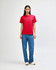 A red heavyweight cotton unisex T-shirt displayed on a model, paired with blue cargo pants.