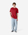 A model wearing a red heavyweight cotton unisex T-shirt paired with light blue jeans and black sneakers.