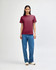 A unisex heavyweight cotton t-shirt in maroon, worn with light blue baggy jeans and black sneakers, featuring a logo.
