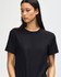 A unisex heavyweight cotton T-shirt in black, featuring a logo, worn by a model with a shaved head.