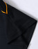 A black polo shirt with orange detailing on the collar and sleeves, featuring a logo.
