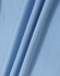 A close-up of light blue fabric, showcasing the texture and folds of a polo shirt material.