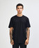 A model wearing a black unisex short sleeve t-shirt, paired with blue jeans. The t-shirt features a logo.