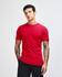 A red unisex fine jersey short sleeve t-shirt displayed on a model with curly hair. It features a logo.