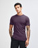A purple unisex short sleeve t-shirt displayed on a model with straight, long hair. The shirt has a logo.