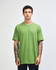 A green unisex short sleeve T-shirt displayed on a male model, featuring a simple design and a logo.