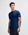 A side view of an American Apparel unisex fine jersey short sleeve t-shirt in teal. The model has curly hair.