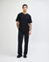 A black unisex fine jersey short sleeve t-shirt displayed on a model, featuring a simple design and relaxed fit.